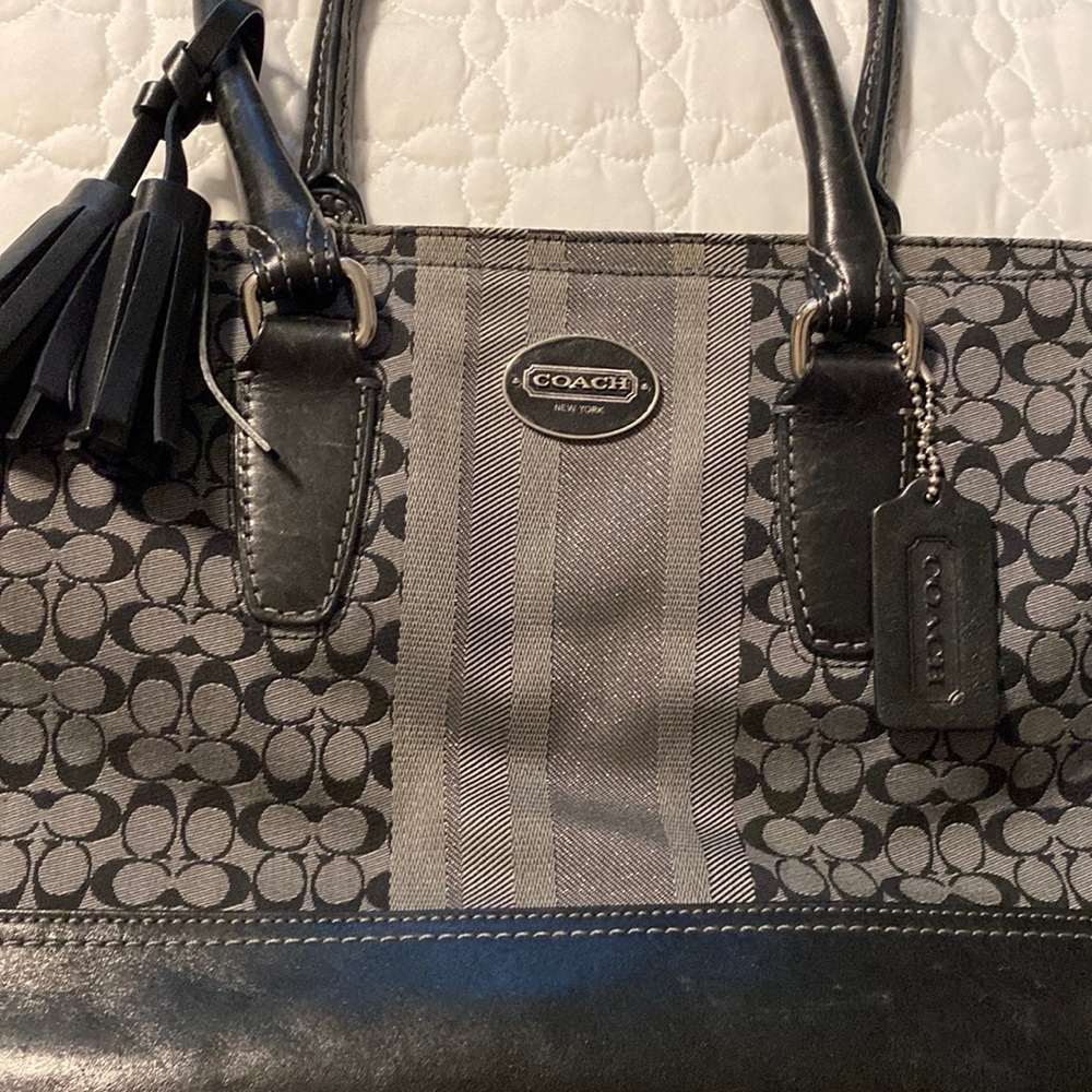Black and grey Coach small shoulder bag with black tassel.